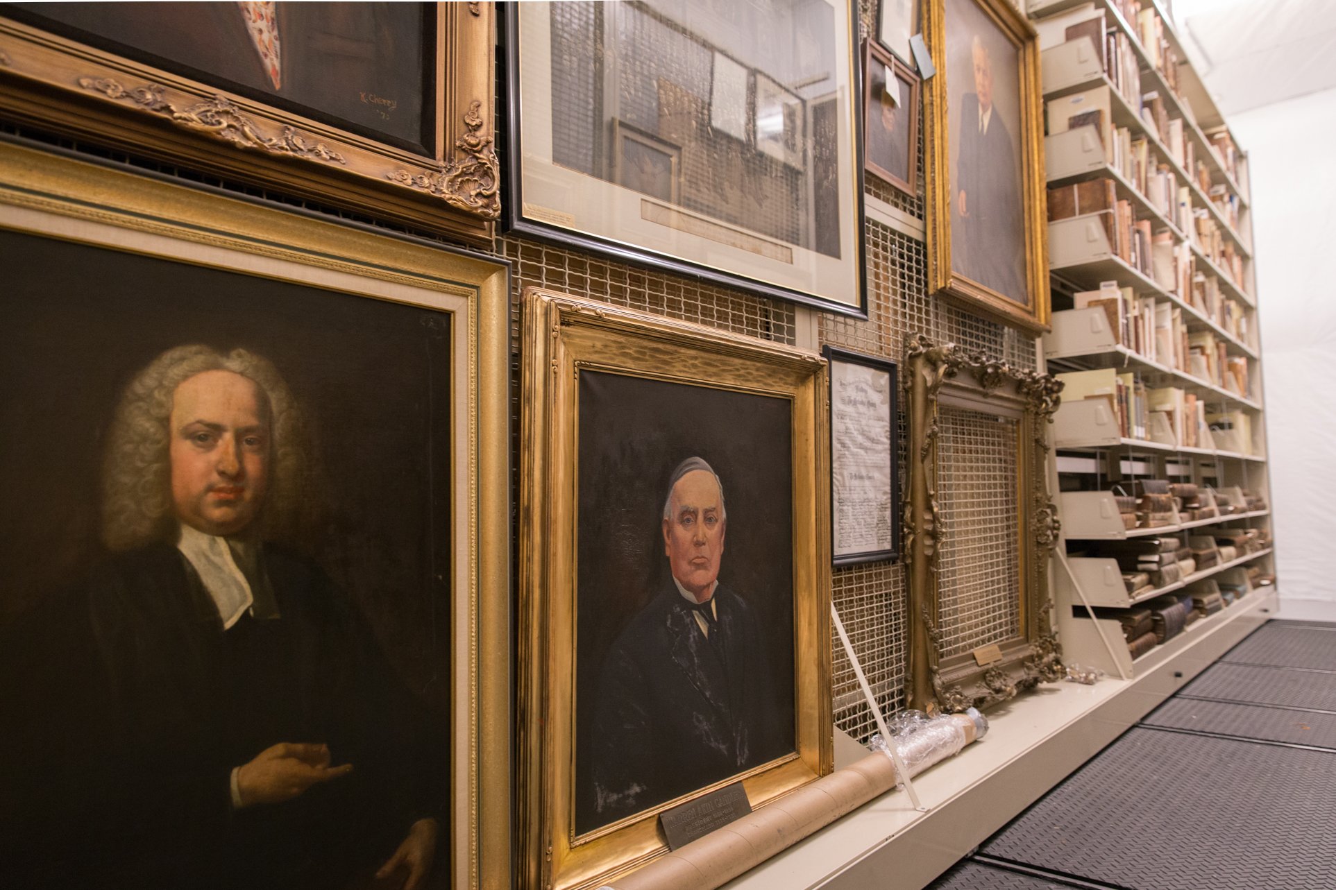 library stores portraits and books on mobile shelving