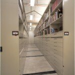Compact mobile library storage featuring metal cabinets on rails