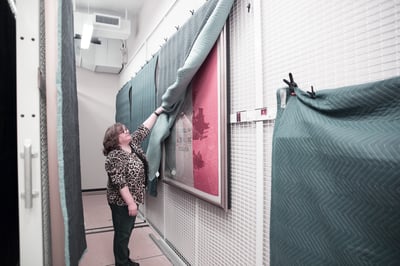 Wall mounted art racks protected by tambour doors