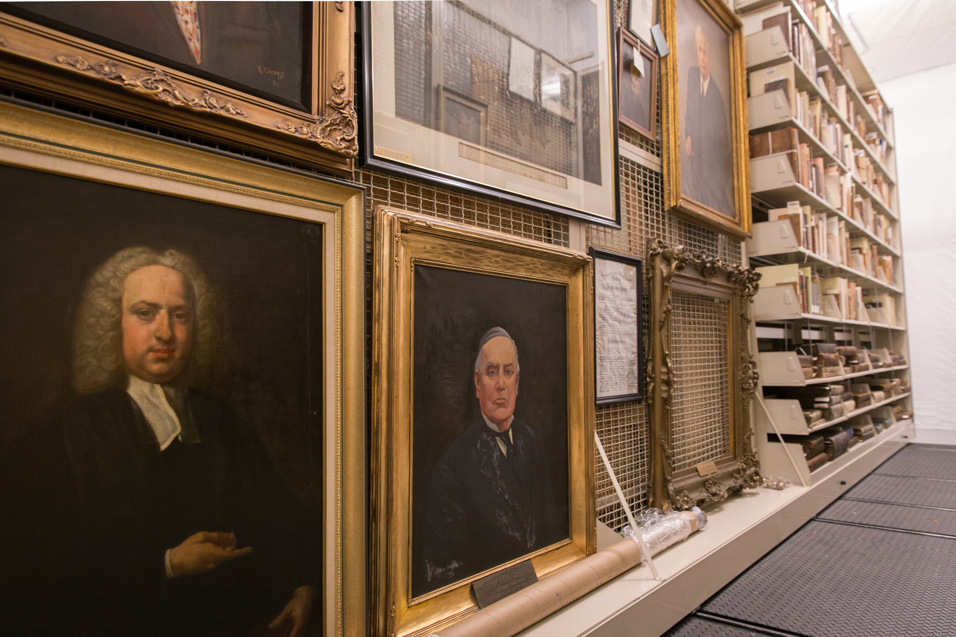 library stores portraits and books on mobile shelving with art racks