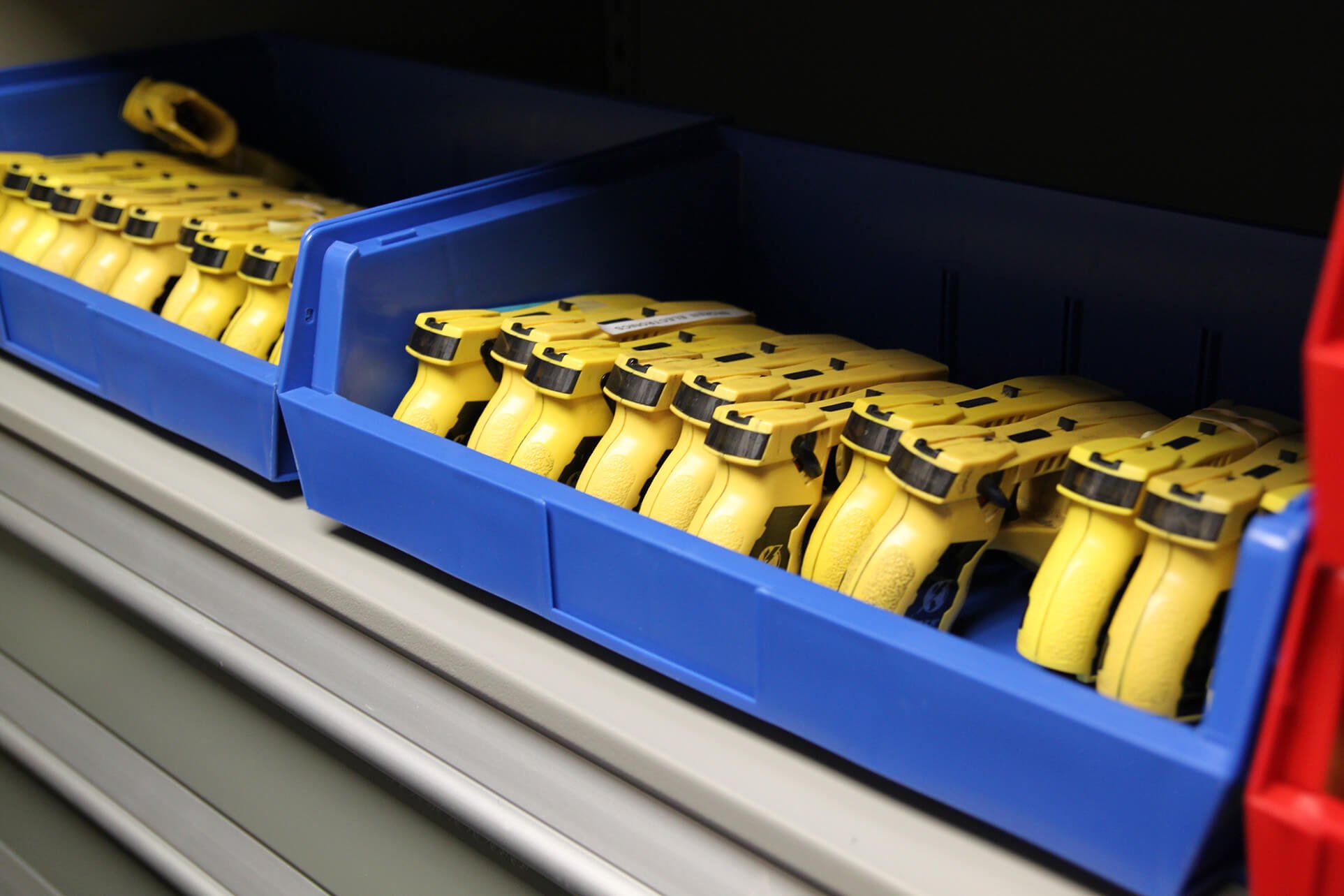 Taser equipment in bin storage on powered compact shelving